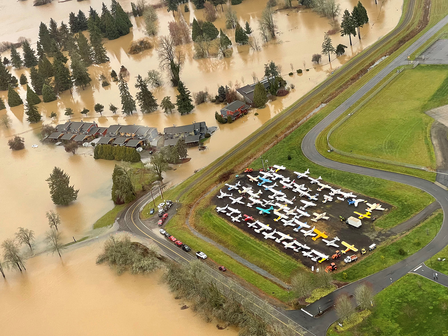 Flooded houses, with water about to encroach on the airport.